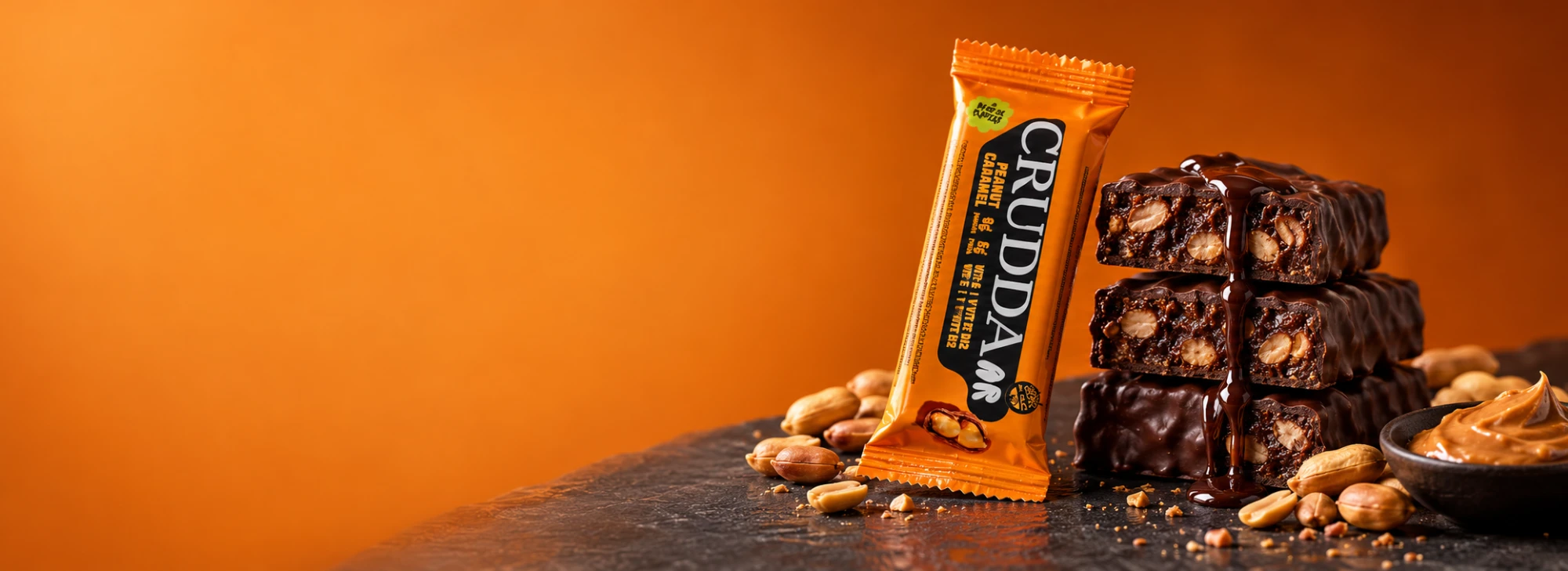 Barra Crudda Bar Peanut Caramel junto a barras bañadas en chocolate con maní
